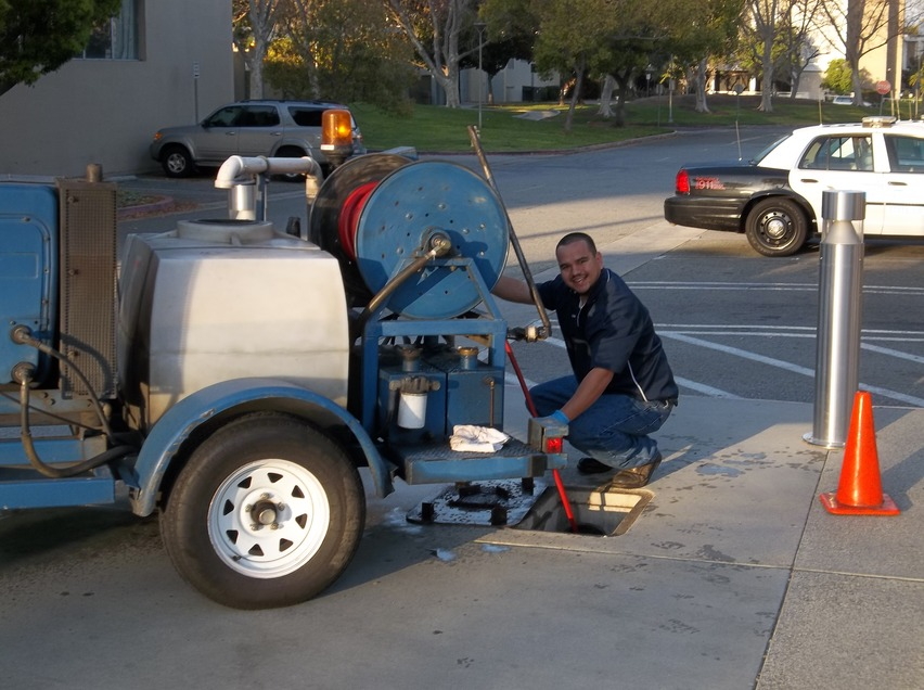 A smiling, professional technician begins to jet an office building main line